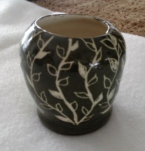 When the clay is still wet, you "paint" it with a paint called a slip. After it dries, you carve out a pattern and then fire the piece. After that I added a clear glaze.